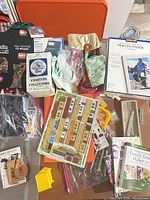 Overview of lot showing photo paper, manuals, coasters pack, KeySmart, pencils, fabric pieces