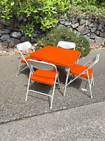 Complete set: orange folding table with four matching chairs