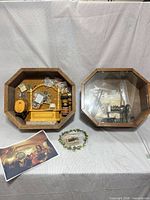 Both octagonal shadow boxes with contents and loose accessories on table