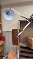 Full view of articulated floor lamp with wood post and metal shade
