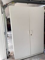 Front view of tall white 2-door cabinet