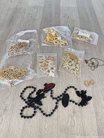 Lot overview showing sealed rhinestone chain bags, Fireball bead necklace, hoop earrings, small chain