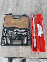 Tap and die set open alongside torque wrench case