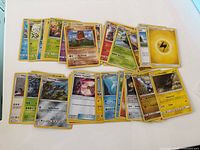 Spread of approx. 35 Pokémon cards showing mix of Pokémon, Trainer and Energy cards