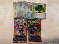 Stack of Pokémon TCG cards and two Phantasmal Flames booster packs displayed on surface