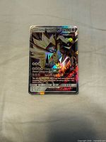 Front of holographic Dusk Mane Necrozma GX card showing artwork, HP and set number