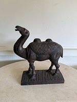 Front-left view of bronze camel statue on base