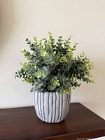 Front view of artificial plant showing foliage and ceramic pot