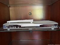 Front view of Hitachi DV-P745U DVD player with remote resting on top