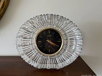 Front view of Hoya crystal mantel clock showing oval faceted body and dial
