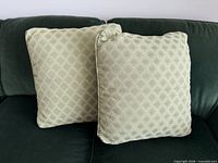 Two Kravet lime green chenille pillow covers on dark sofa