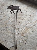 Full view of metal moose silhouette on long rod