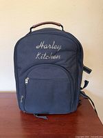 Front view of black embroidered picnic backpack