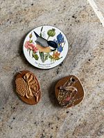 Three small art pieces laid on stone surface