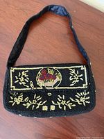Front view of black beaded handbag showing floral basket motif and gold bead designs
