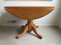 Table with leaves down showing slim profile and pedestal base