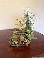 Front view of moss-roof fairy house with florals, bird and eggs