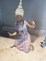 Full view of kneeling Thai dancer figurine, front angle showing costume and pose