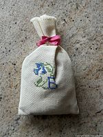 Front view showing embroidered letter and flower