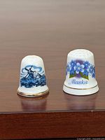 Front view of two porcelain thimbles showing designs