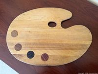 Top view of wooden palette showing thumb hole and inlays