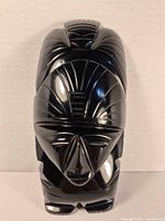 front view of black carved stone figurine