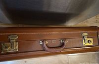 Top view of brown travel case showing brass latches and leather handle