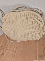 Front view showing wave texture, top handle and crossbody strap