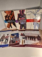 Front view showing all seven paperback books: three Umbrella Academy graphic novels and four Osprey British military history titles