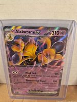 Front view of Alakazam ex holographic card in top loader