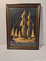 Full view of framed straw marquetry sailing ship artwork