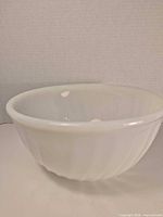 Oblique view showing exterior fluted design of white milk glass bowl