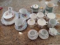 Group shot of all cups, saucers, teapot and pitchers on countertop