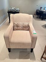 Front view of beige armchair with lumbar pillow