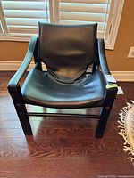 Front view of black faux leather sling armchair