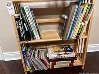Two-shelf wooden rack with assorted books, spines visible