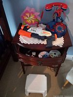 Overall lot on bedside table showing Nerf blaster, Spider-Man phone, DVDs and step stool
