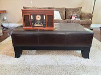 full side view of ottoman showing faux leather surface and legs
