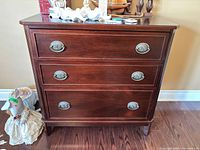 Front view showing three drawers and hardware