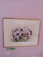 Framed watercolor of pansies on wall