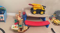 Wide view showing picnic table, dump truck on top, pirate ship beside