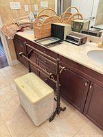 Group shot showing towel rack, hamper, baskets, heater and radio on vanity