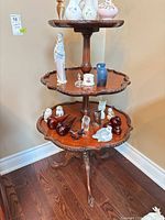 full view of three-tier pedestal table with mahogany finish
