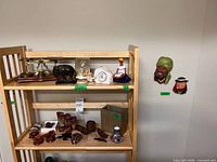 Overview of shelving with scale, figurines, Bossons plaques, wood carvings