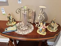 Full lot view showing three figurines, candle holder with glass, and candle