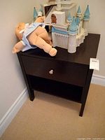 Front view showing drawer, knob, open shelf, and overall design