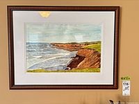 Framed seascape painting on wall showing full frame and mat