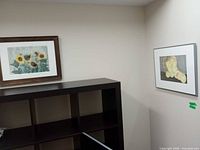 Both framed paintings on wall showing relative size and frames