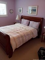 Full view of assembled queen sleigh bed with bedding