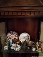 Cabinet shelf showing full assortment of plates, eggs, figurines and teacup